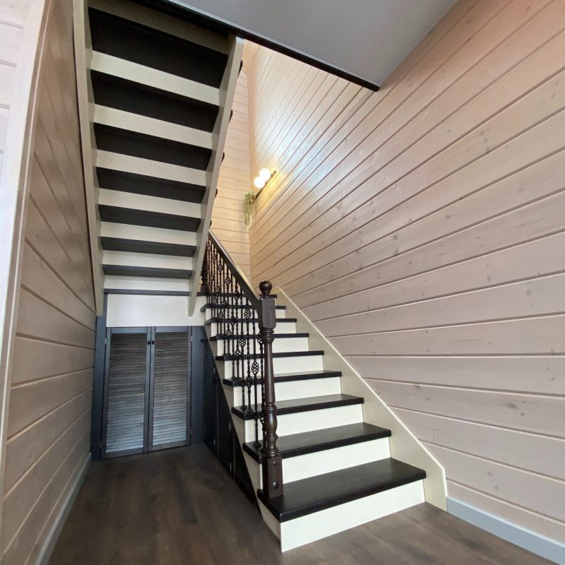 Деревянная лестница из лиственницы с ковкой и кладовкой