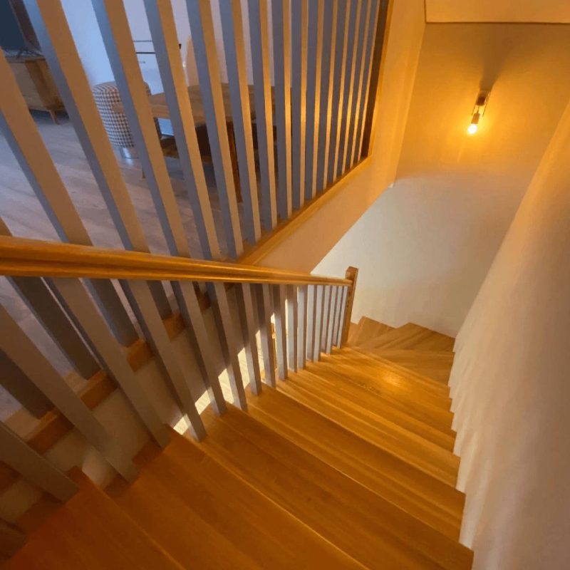 Г-образная лестница на двойном косоуре из листа и деревянным ограждением