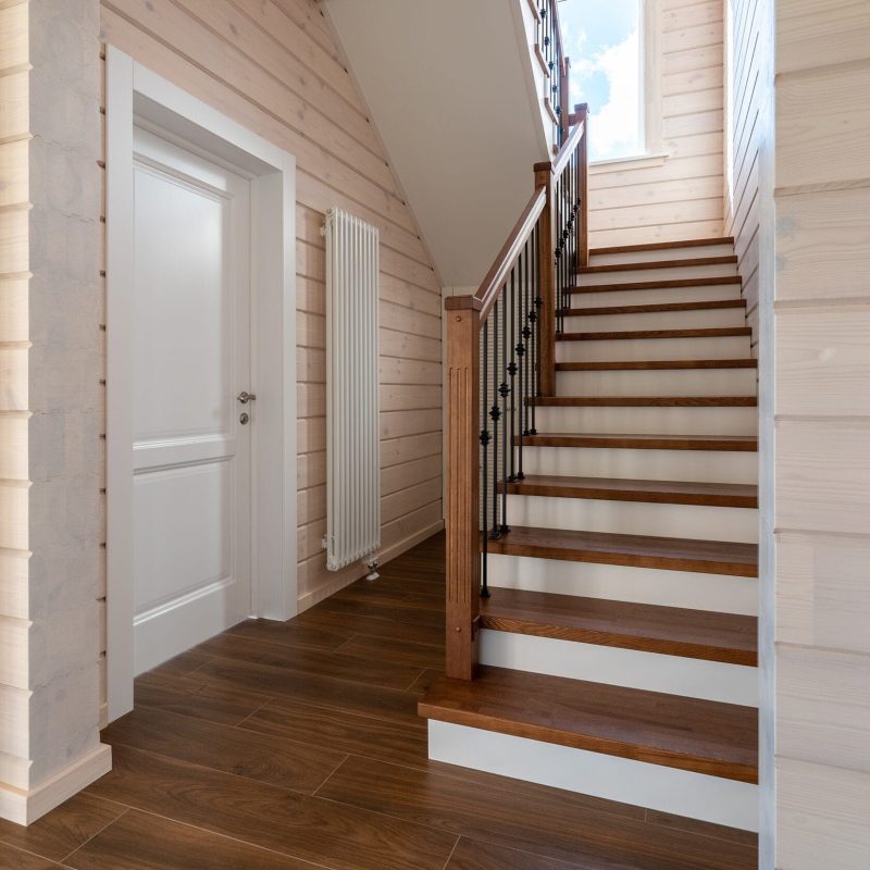 Обшивка металлического каркаса лестницы ясенем в брусовом доме