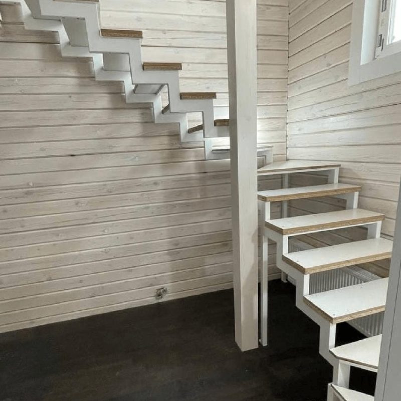 Трехмаршевый каркас лестницы на двух косоурах в брусовом доме с забежными ступенями