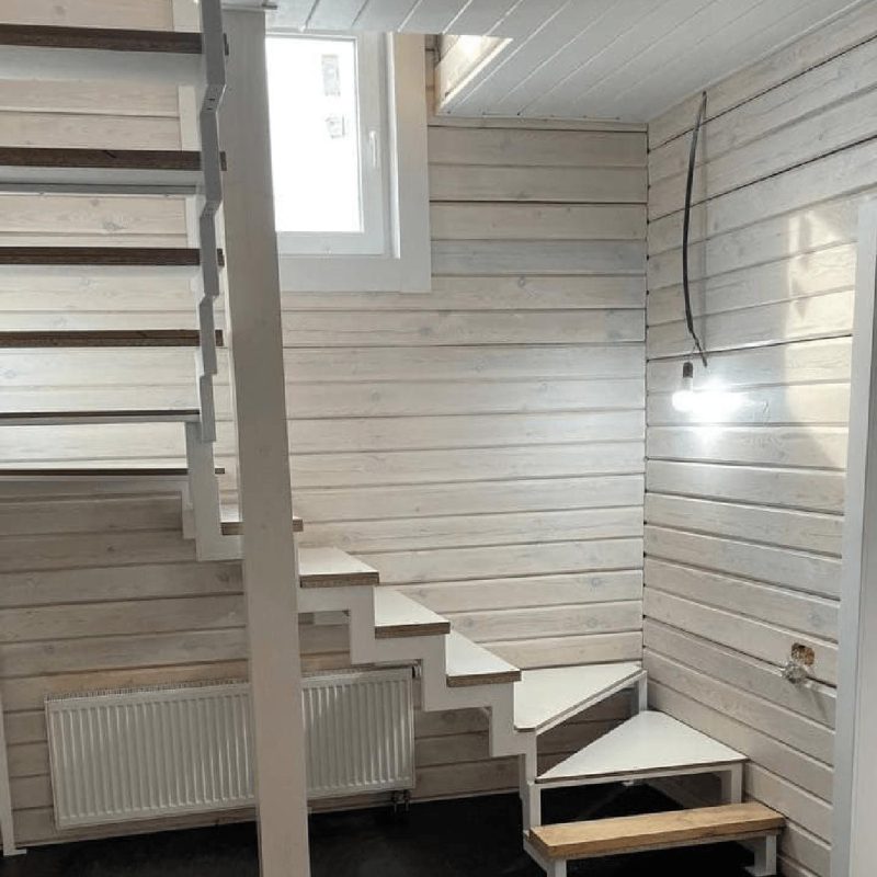 Трехмаршевый каркас лестницы на двух косоурах в брусовом доме с забежными ступенями