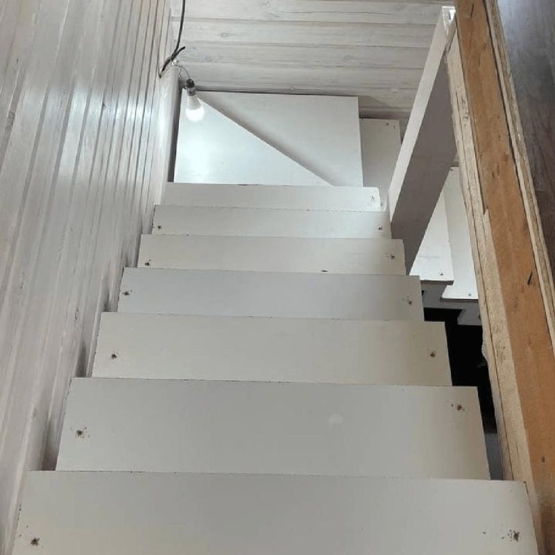 Трехмаршевый каркас лестницы на двух косоурах в брусовом доме с забежными ступенями