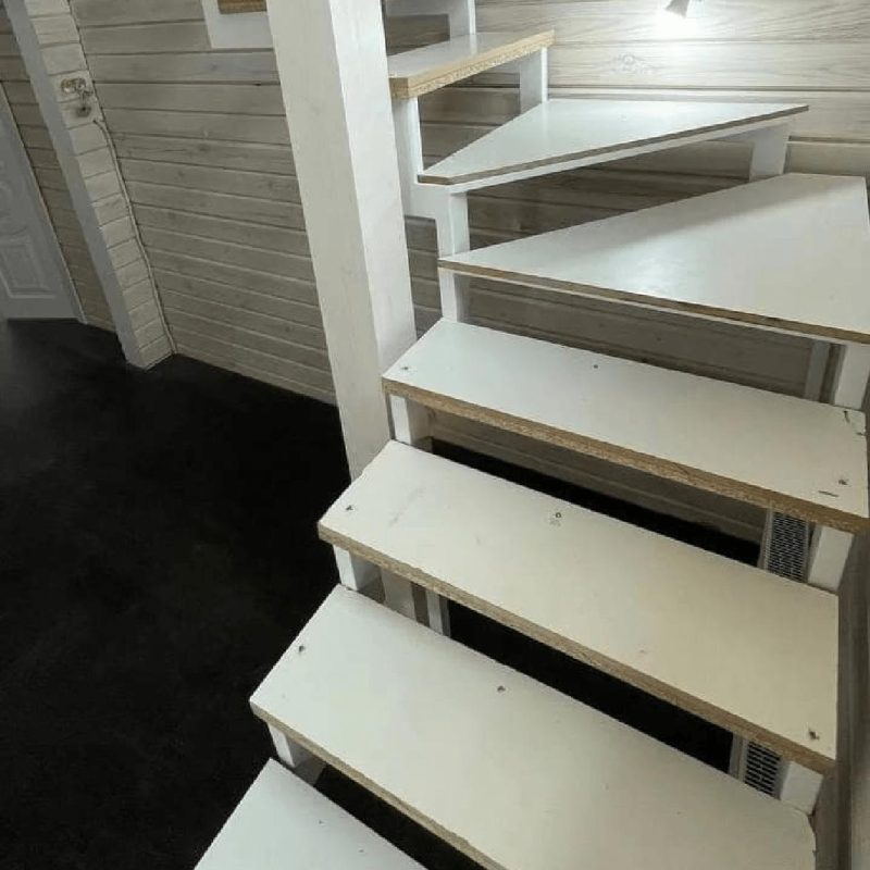 Трехмаршевый каркас лестницы на двух косоурах в брусовом доме с забежными ступенями