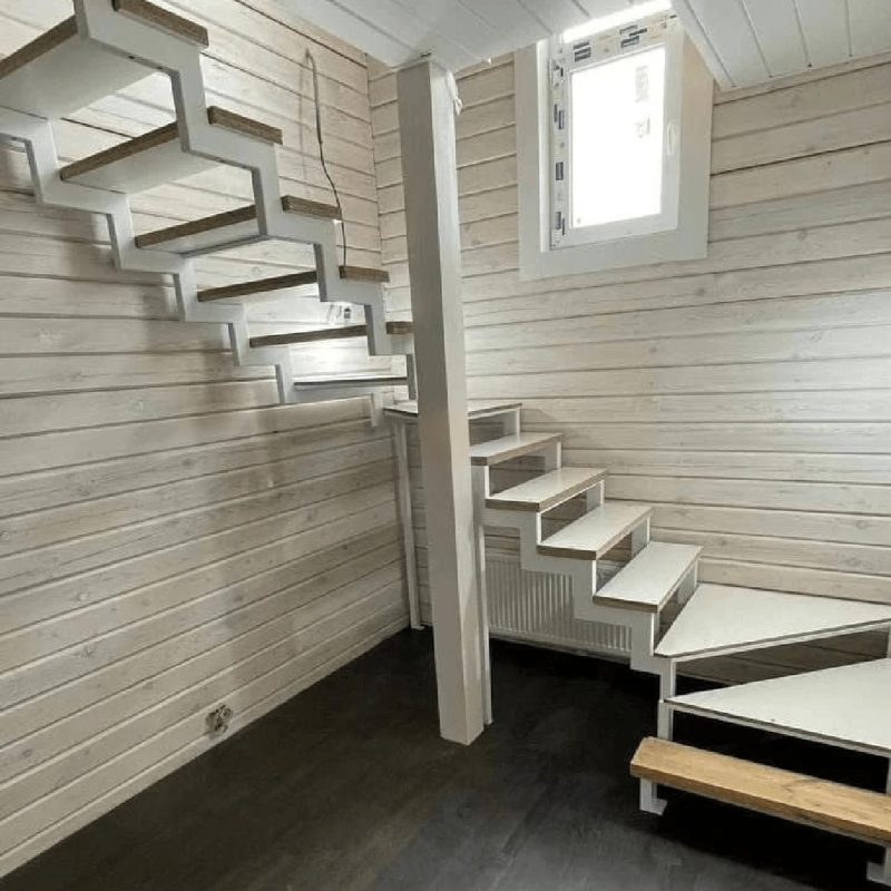 Трехмаршевый каркас лестницы на двух косоурах в брусовом доме с забежными ступенями