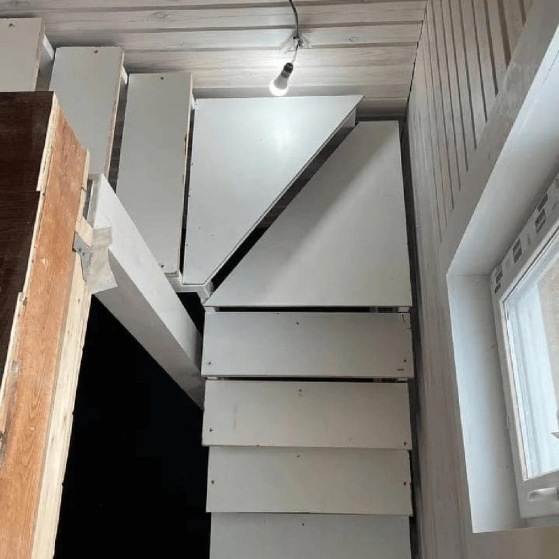 Трехмаршевый каркас лестницы на двух косоурах в брусовом доме с забежными ступенями