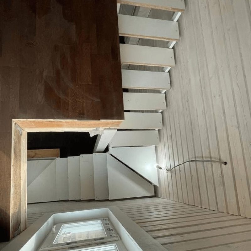 Трехмаршевый каркас лестницы на двух косоурах в брусовом доме с забежными ступенями